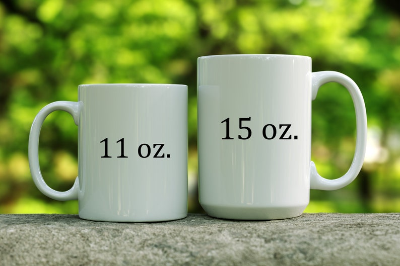 May include: Two white ceramic mugs with black text. The smaller mug is 11 oz and the larger mug is 15 oz.