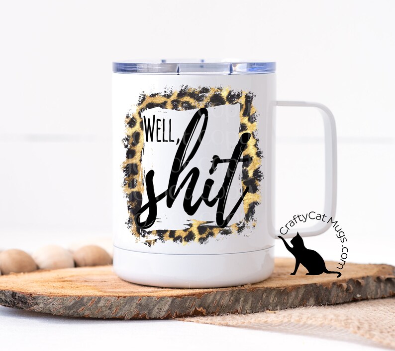 May include: White travel mug with a black and gold leopard print design and the text "Well, shit". The mug has a black cat silhouette on the side with the text "CraftyCat Mugs.com".