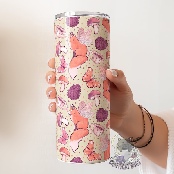 May include: A stainless steel tumbler with a whimsical design featuring foxes with wings, mushrooms, butterflies, and teacups on a light beige background.