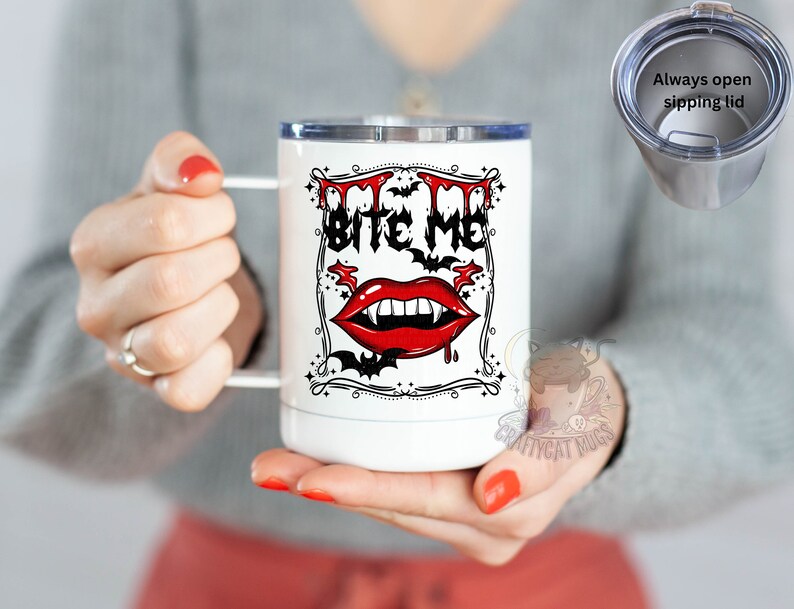 K&ouml;nnte beinhalten: Wei&szlig;e Edelstahl-Reisebecher mit einer schwarzen und roten Grafik eines Vampirmundes mit Z&auml;hnen und dem Text "Bite Me". Der Becher hat einen durchsichtigen Deckel mit einem schwarzen Schieberegler.