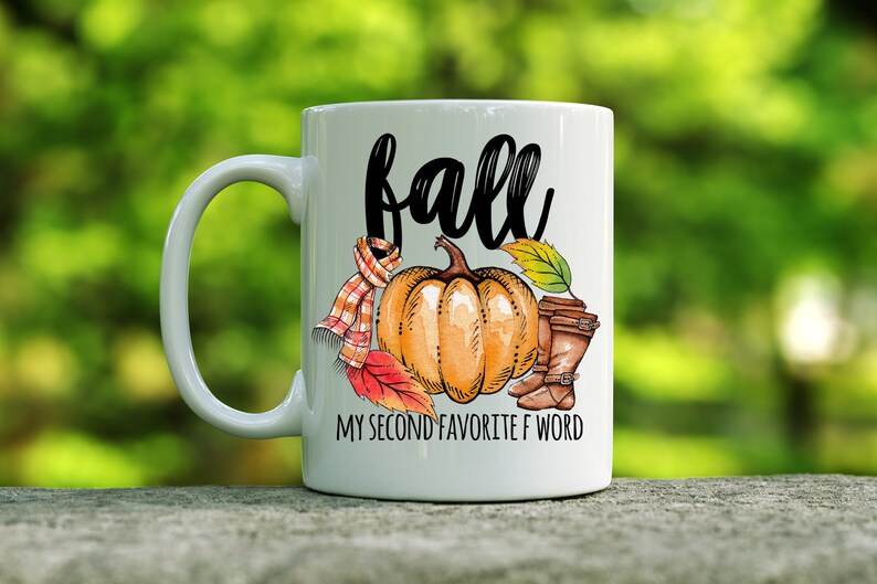 May include: White ceramic coffee mug with a black and white graphic of a pumpkin, leaves, boots, and a scarf. The text "fall" is written in black cursive lettering. The text "My second favorite F word" is written in black below the graphic.