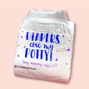 Puede incluir: Un pañal blanco con el texto "DIAPERS are my POTTY! (my mommy says so!)" en letras azules y moradas. El pañal está decorado con pequeños corazones rosas y estrellas moradas.