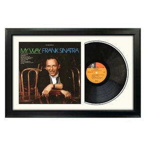 May include: A black framed record album display with a white mat. The album cover features a black and white photo of Frank Sinatra with the title "My Way" in blue and white text. The record is black with a white label.