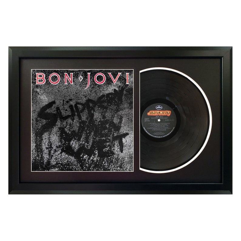 May include: A framed black vinyl record with a black and white album cover. The album cover features the text "BON JOVI" and "SLIPPERY WHEN WET".