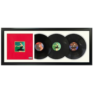 May include: A framed set of three vinyl records with a red album cover featuring a woman in a black dress. The album cover has a green background and the text "PARENTS" is visible on the cover. The records are black with a white label and the same image as the album cover.