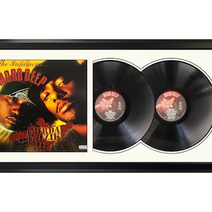 May include: A framed double LP record set of Mobb Deep's album "The Infamous..." with a black frame and a white mount. The album cover features a yellow and red design with the text "The Infamous... Mobb Deep" and "Murda Muzik 1995".