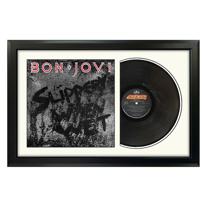 May include: A framed black vinyl record with a white mat. The record is by Bon Jovi and the album title is "Slippery When Wet".