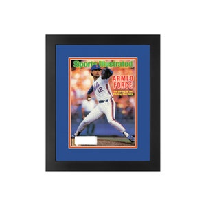 May include: A framed Sports Illustrated magazine cover featuring a baseball player in a blue and orange uniform pitching. The cover text reads "ARMED FORCE Ron Darling of the Pitching-Rich Mets".