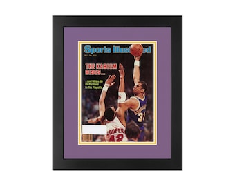 May include: A framed Sports Illustrated magazine cover featuring Kareem Abdul-Jabbar in a Lakers uniform, with the headline "The Kareem Rises... And Whips Up On Portland In The Playoffs".