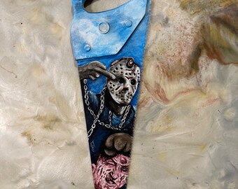 May include: A hand-painted saw with a blue background and a depiction of Freddy Krueger and Jason Voorhees. The saw handle reads "Freddy vs Jason".