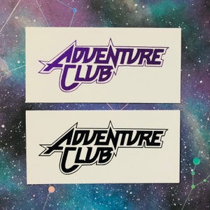 May include: Two white cards with the text "Adventure Club" in a stylized font. The top card has the text in purple, and the bottom card has the text in black.