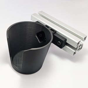 May include: A black 3D printed cup holder attached to a silver aluminum extrusion.