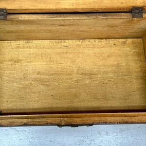 May include: An open, rectangular wooden box with a hinged lid. The interior is empty, revealing the natural wood grain. The box is constructed with dovetail joints and metal hinges, suggesting a vintage or handcrafted item.