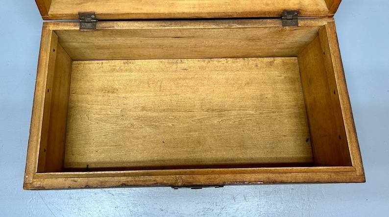 May include: An open, rectangular wooden box with a hinged lid. The interior is empty, revealing the natural wood grain. The box is constructed with dovetail joints and metal hinges, suggesting a vintage or handcrafted item.