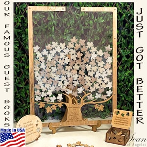 May include: A wooden guest book in the shape of a tree with leaves that guests can sign. The tree is made of wood and has a clear acrylic front. The leaves are made of wood and are attached to the tree with a small pin. The guest book is on a wooden stand and has a small box with extra leaves. The guest book is a unique and creative way to capture memories from a special event.
