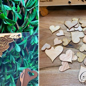 May include: A wooden wedding guest book with a floral design and small wooden hearts. The guest book has a clear acrylic front and a wooden stand. The date "August 14, 2024" is visible on the top.