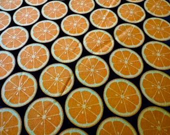 オレンジスライスが描かれた黒の43インチ幅100%コットンノベルティ生地