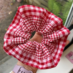 May include: Red and white gingham hair scrunchie with a ruffled edge.