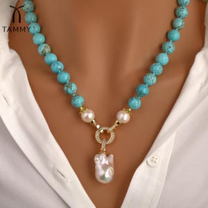 May include: A turquoise and gold necklace with a large baroque pearl pendant. The necklace is made of round turquoise beads and has a gold clasp with a small circle of clear stones.