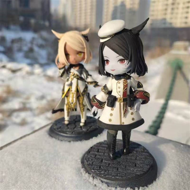 K&ouml;nnte beinhalten: Zwei kleine, detaillierte Figuren von Anime-Charakteren. Die Figur links ist eine blonde weibliche Figur mit einem wei&szlig;en und goldenen Outfit. Die Figur rechts ist eine weibliche Figur mit schwarzen Haaren und einem wei&szlig;en und roten Outfit. Beide Figuren stehen auf schwarzen runden Sockeln.