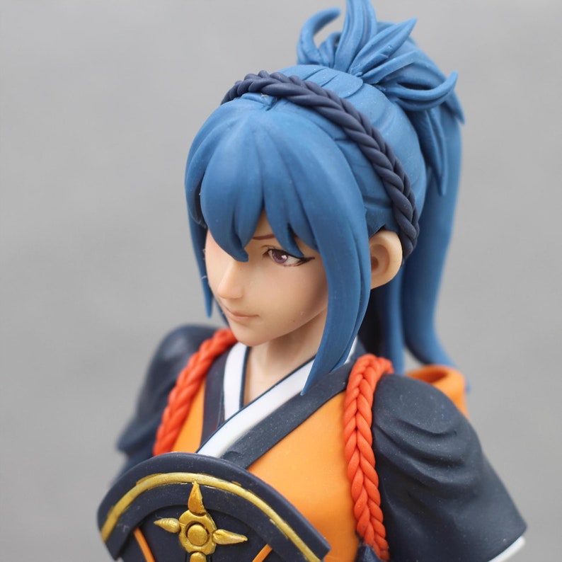 May include: A blue haired figurine wearing a black and orange kimono with a red braided cord. The figurine has a black headband with a braid in the back of her hair. The figurine is holding a fan with a gold and black design.