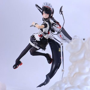 Könnte beinhalten: Detaillierte Actionfigur eines Charakters in einem Maid-Outfit, mit einem schwarz-weißen Farbschema mit roten Akzenten. Die Figur hat schwarzes Haar, rote Augen und ist dynamisch mit einer Waffe posiert. Die Figur steht auf einem transparenten Ständer.