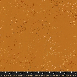 May include: Mustard-coloured fabric with a speckled pattern. The fabric features small, irregular spots in shades of white, brown, and tan scattered across the surface. The text "RUBY STAR SOCIETY" is printed at the bottom.