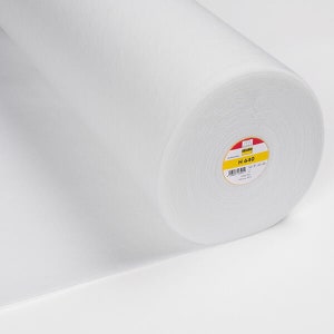 May include: A roll of white fabric, possibly interfacing or wadding, is shown against a white backdrop. The fabric is tightly rolled, revealing the material's cross-section. A label with the text "H 640" is visible on the end of the roll.