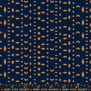 May include: Dark blue fabric featuring a repeating pattern of gold shapes, including diamonds, circles, and crescent moons. Vertical lines of small gold rectangles and dots create a structured design. The text "RUBY STAR SOCIETY" is at the bottom.