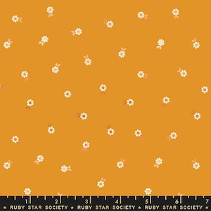 May include: Mustard yellow fabric featuring a repeating pattern of small white daisies with yellow centres and peach-coloured leaves. The fabric has a ruler at the bottom with the text "RUBY STAR SOCIETY".
