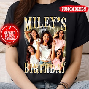 Puede incluir: Camiseta negra con un dise&ntilde;o personalizado. El dise&ntilde;o presenta el texto "MILEY'S 23rd BIRTHDAY" en letras doradas, junto con varias im&aacute;genes de una mujer. La mujer posa con signos de paz y sacando la lengua. Tambi&eacute;n son visibles las palabras "CUSTOM DESIGN" y "CREATED BY REAL ARTISTS".