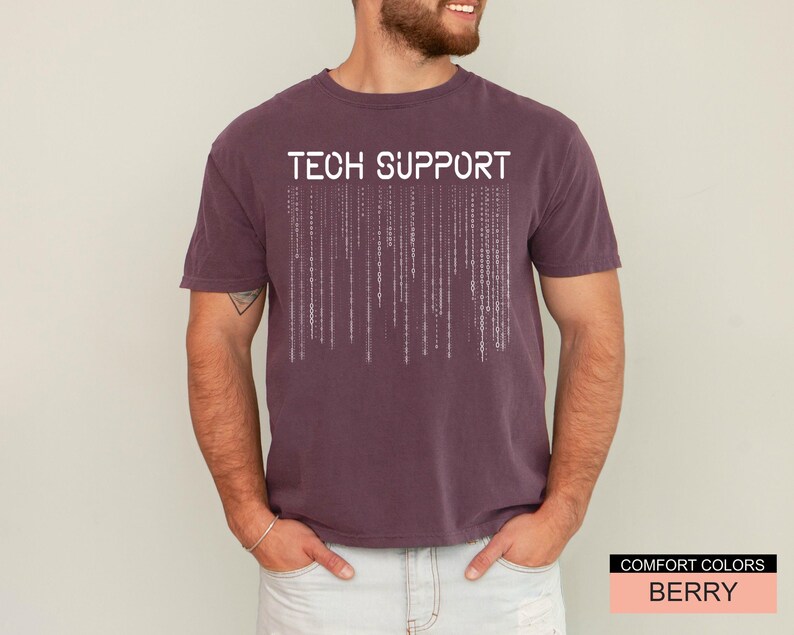 K&ouml;nnte beinhalten: Beerenfarbenes T-Shirt mit den Worten "TECH SUPPORT" in wei&szlig;en Blockbuchstaben &uuml;ber einem vertikalen Bin&auml;rcode-Design. Das Shirt ist von der Marke Comfort Colors.