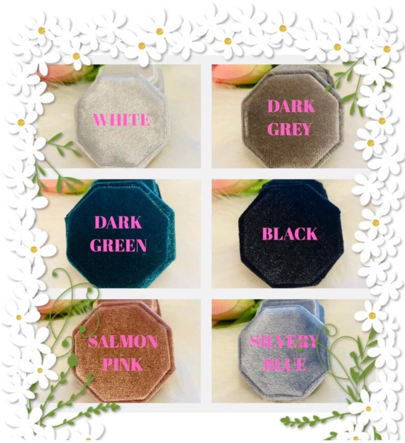 May include: Six octagonal velvet ring boxes in white, dark grey, dark green, black, salmon pink, and silvery blue. Each box features a soft, textured finish and is labeled with its corresponding color in pink text centered on the lid.