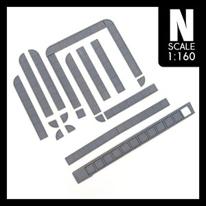 May include: A set of grey plastic model railway track pieces in N scale, 1:160 scale. The pieces include straight track, curved track, and a platform.