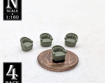 May include: Four miniature olive green armchairs, possibly for a model railway or dolls' house. The chairs are shown on a penny for scale. The image includes text that reads "N SCALE 1:160" and "4 PACK".