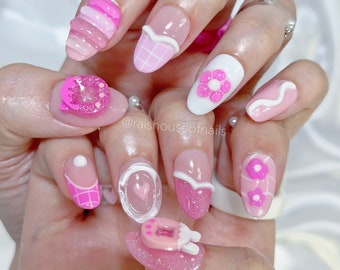 Uñas postizas de gelatina rosa con dijes de mascota virtual 3D, flor y brillantina.