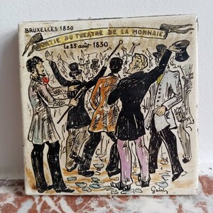 May include: A vintage tile depicting a scene from the 1830s in Brussels, Belgium. The tile shows a crowd of people exiting the Theatre de la Monnaie, with the text "BRUXELLES 1830 SORTIE DU THEATRE DE LA MONNAIE Le 25 août 1830" visible at the top.