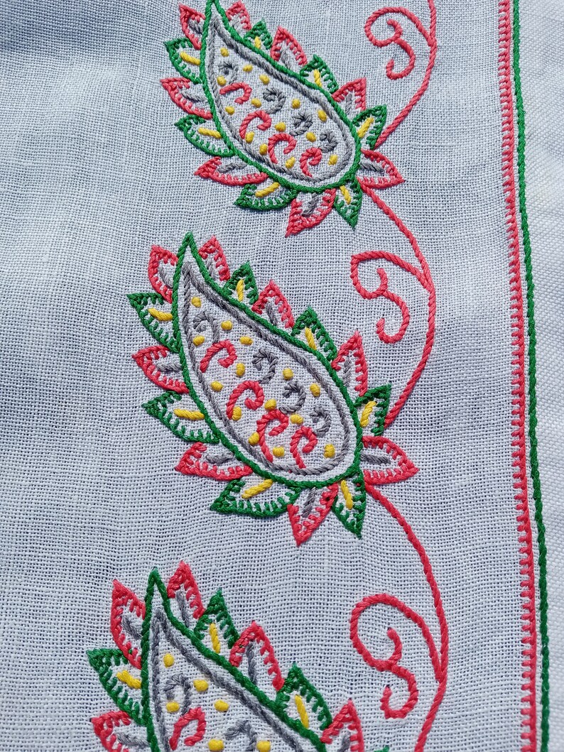 May include: White fabric with a red, green, and gray paisley embroidery design. The paisley design is repeated three times down the fabric.
