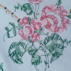May include: White fabric with embroidered pink and green flowers. The flowers are detailed with pink and white stitching. The leaves are green with a striped pattern.