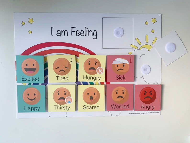 May include: A colorful felt board with the words "I am Feeling" at the top. The board has a rainbow arc and a sun with clouds. There are nine different emotion cards with various facial expressions and words like "Excited", "Tired", "Hungry", "Sick", "Happy", "Thirsty", "Scared", "Worried", and "Angry".