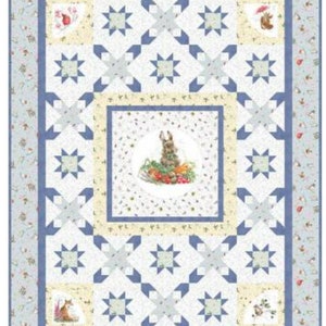 May include: A white quilt with a blue and yellow border. The center of the quilt features a large star design with a smaller star design in each corner. The quilt is decorated with a variety of small images, including a rabbit, a bird, and a mushroom.