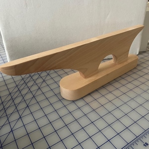 Può includere: Un battente da sarto in legno, uno strumento per stirare le cuciture. Il battente è realizzato in legno chiaro e ha una parte superiore lunga e angolata con una base arrotondata. È dotato di un'apertura per l'impugnatura. Per stirare tessuti.