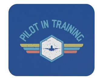 Puede incluir: Alfombrilla de ratón azul con un diseño de estilo vintage que presenta un avión en un hexágono con alas y el texto "Pilot in Training".