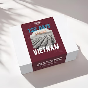 May include: A white box with a burgundy band featuring the text "12 DAYS AROUND VIETNAM." The band includes a black and white photo of a field and the phrase "YOUR PHENOMENAL JOURNEY STARTS HERE."