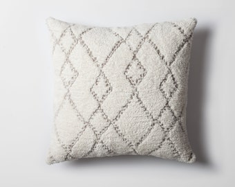 May include: A white throw pillow with a grey diamond pattern. The pillow is made of a soft, fluffy material.