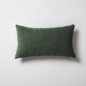 May include: A green rectangular pillow with a textured herringbone pattern.