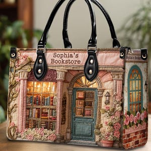 May include: A tote bag featuring a bookstore design with the text "Sophia's Bookstore." The bag has black handles and a detailed illustration of a bookstore facade with books, flowers, and a blue door.