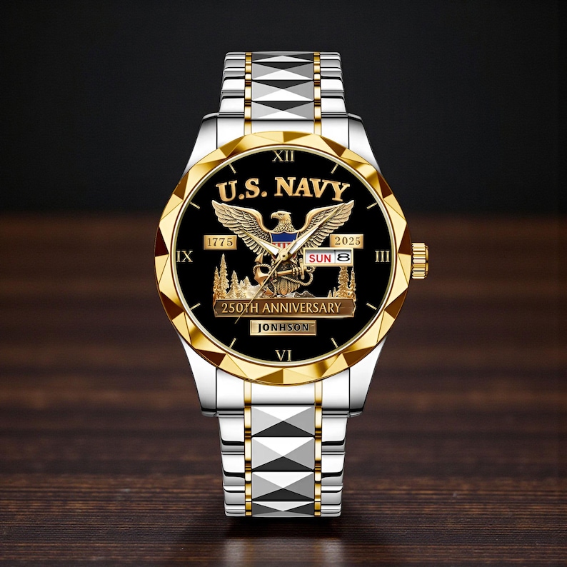 May include: A silver and gold wristwatch with a black face. The watch features the text "U.S. NAVY" and an eagle emblem. The watch also displays "250TH ANNIVERSARY" and the name "JONHSON". The watch band is silver with gold accents.