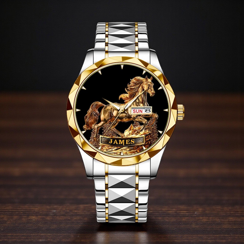 May include: A gold and silver wristwatch with a detailed gold horse design on a black face. The watch has a gold bezel and a silver band. The word "JAMES" is displayed on the watch face.
