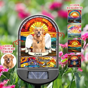 May include: A solar-powered stained glass memorial garden stake with a golden retriever dog wearing angel wings. The stake features a rainbow sunset background and the text "I Am Always With You".